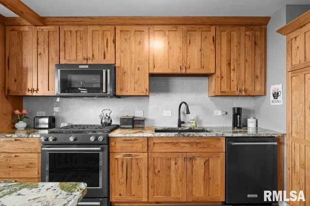 a kitchen with stainless steel appliances granite countertop a stove a sink dishwasher and a microwave oven with granite countertops