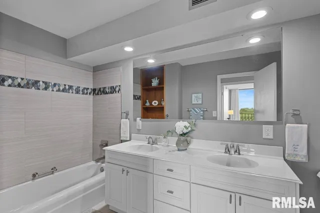 a bathroom with a double vanity sink and a bathtub