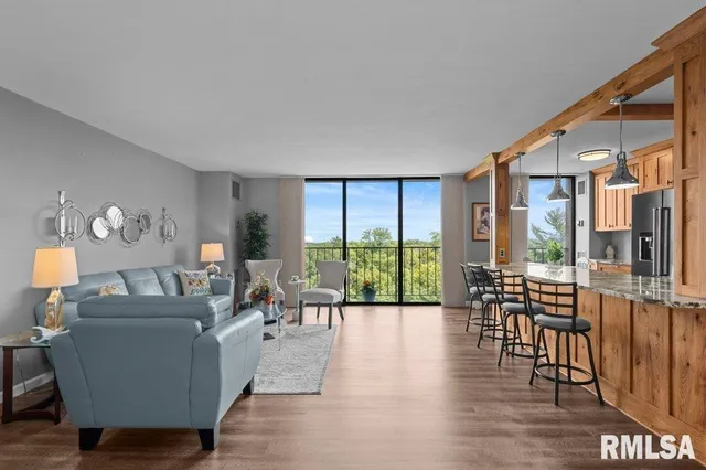 a living room with furniture and a large window with wooden floor