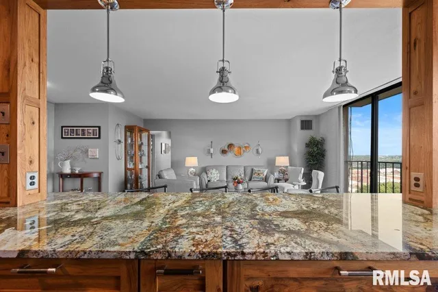 a room with kitchen island sink and wooden floor