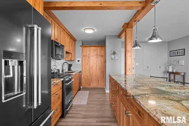 a kitchen with stainless steel appliances granite countertop a refrigerator a stove and a sink