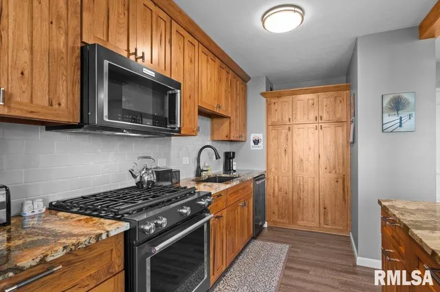a kitchen with stainless steel appliances granite countertop a stove and a microwave