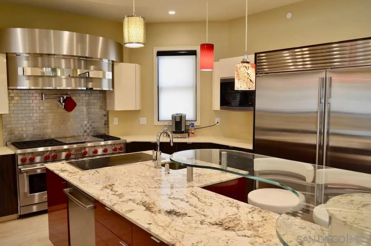 1235 Neptune Avenue Encinitas, CA 92024 - Photo 30 of 32 a kitchen with kitchen island granite countertop a sink and a refrigerator