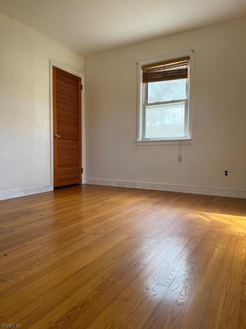 355 Metlars Lane Piscataway, NJ 08854 - Photo 19 of 26 a view of an empty room with wooden floor and a window