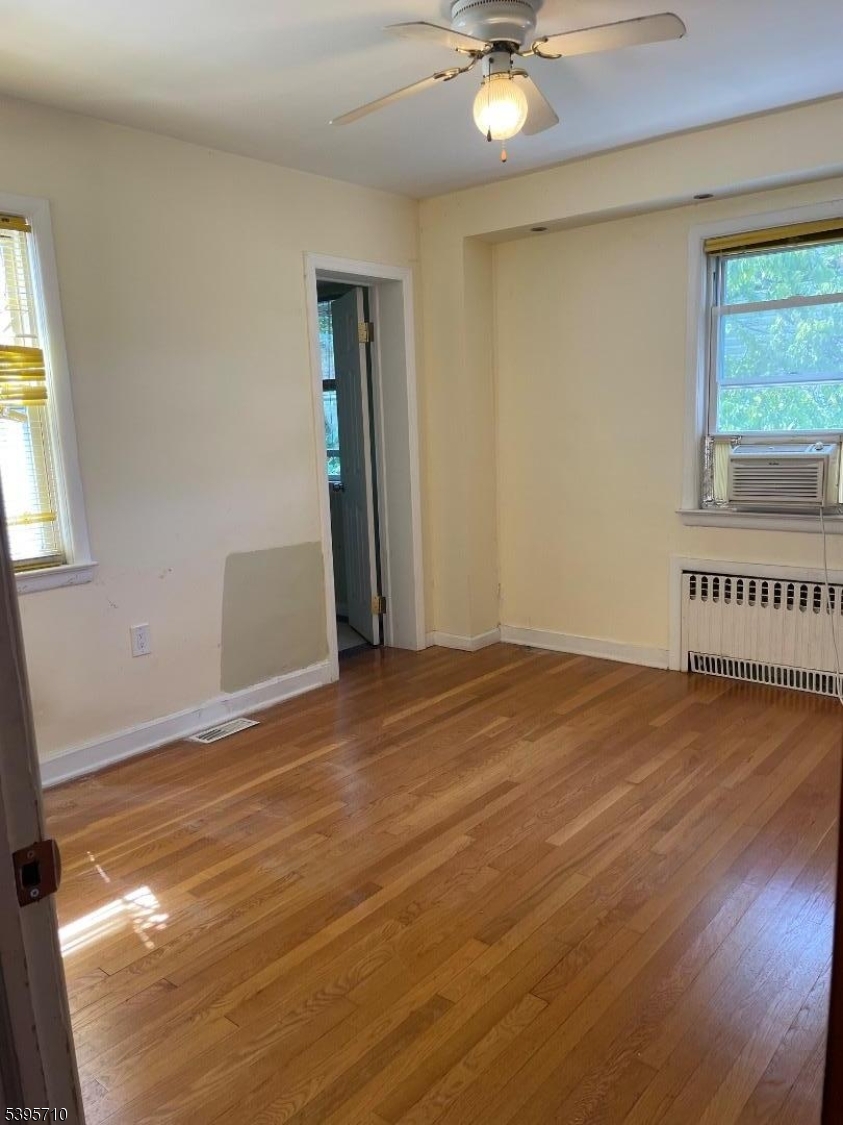 355 Metlars Lane Piscataway, NJ 08854 - Photo 4 of 26 a view of an empty room with window and wooden floor