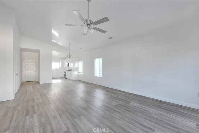 a view of empty room with wooden floor and window