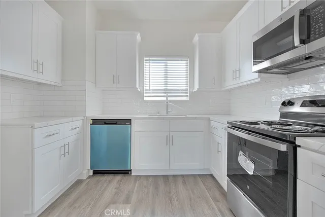 a view of a kitchen with wooden floor and a window