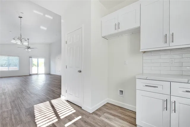 a view of kitchen with granite countertop white cabinets and a wooden floor
