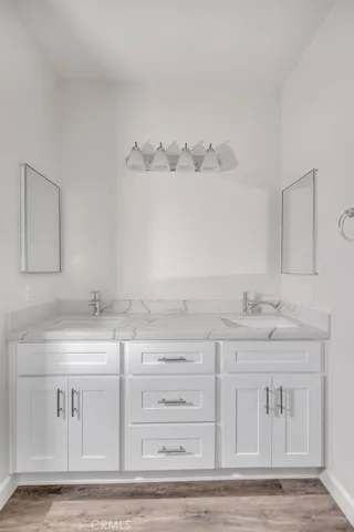 a view of an empty room with wooden floor and window