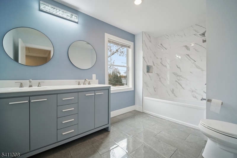 134 Hillside Avenue Livingston, NJ 07039 - Photo 13 of 25 a bathroom with a double vanity sink and a mirror