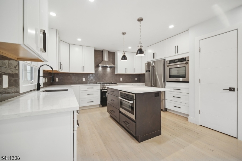134 Hillside Avenue Livingston, NJ 07039 - Photo 5 of 25 a kitchen with stainless steel appliances a stove a sink and a refrigerator