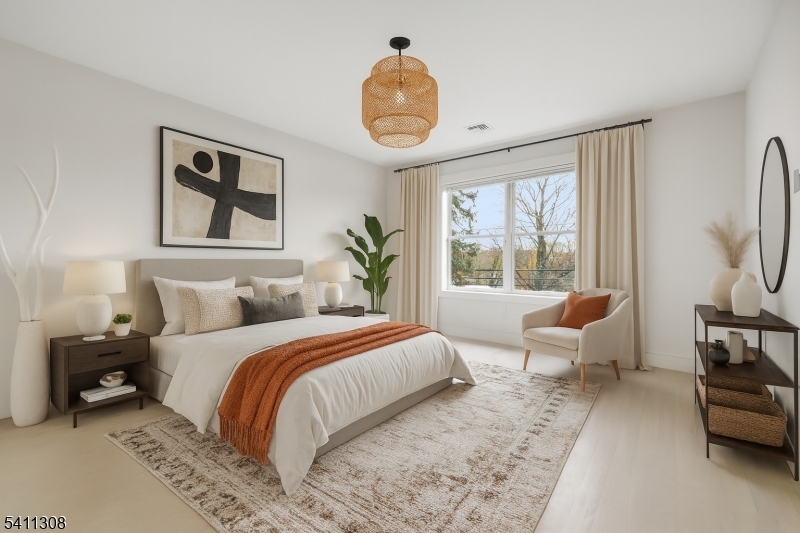 134 Hillside Avenue Livingston, NJ 07039 - Photo 9 of 25 a bedroom with a bed a large window and a chandelier