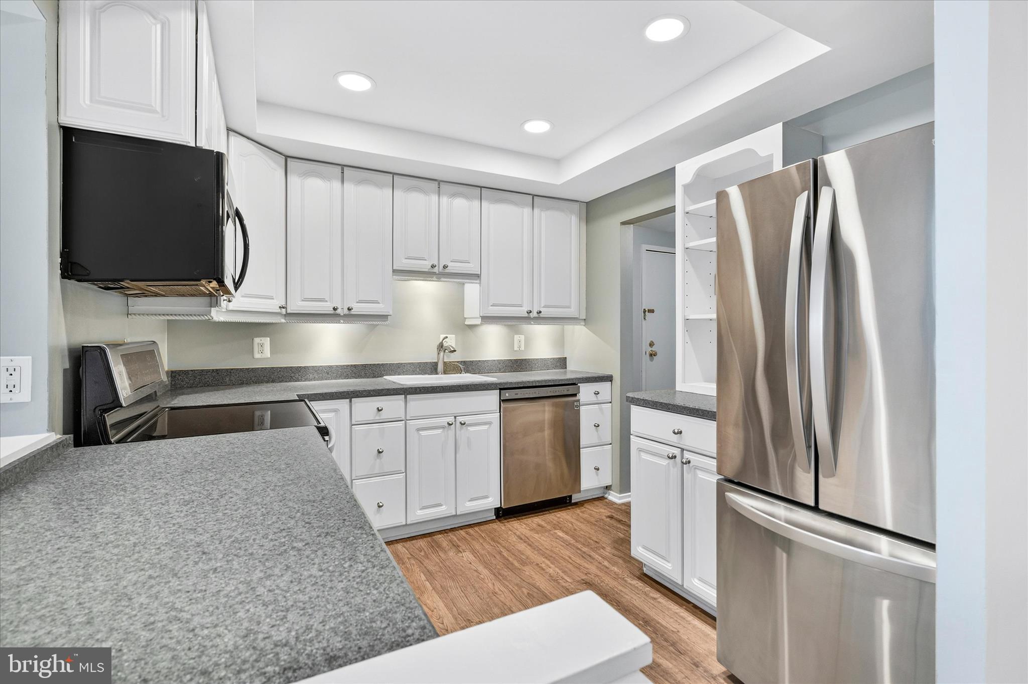 10000 Stedwick Road, Unit 104 Montgomery Village, MD 20886 - Photo 9 of 31 a kitchen with stainless steel appliances granite countertop a refrigerator sink and microwave