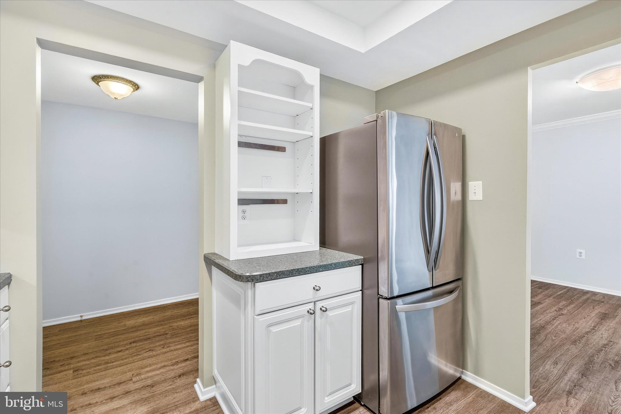 10000 Stedwick Road, Unit 104 Montgomery Village, MD 20886 - Photo 12 of 31 a white refrigerator freezer and a wooden floor