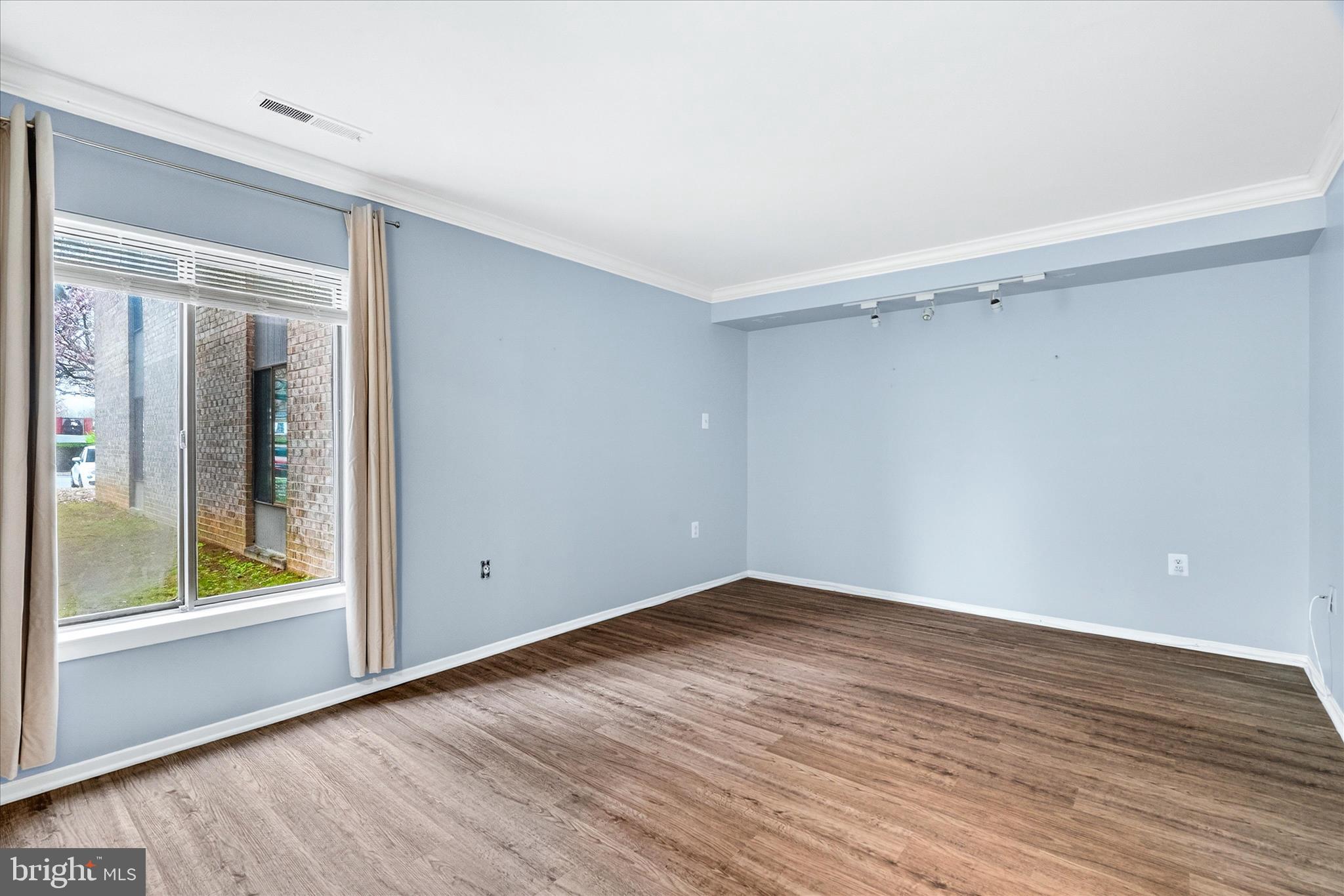 10000 Stedwick Road, Unit 104 Montgomery Village, MD 20886 - Photo 18 of 31 a view of an empty room with wooden floor and a window