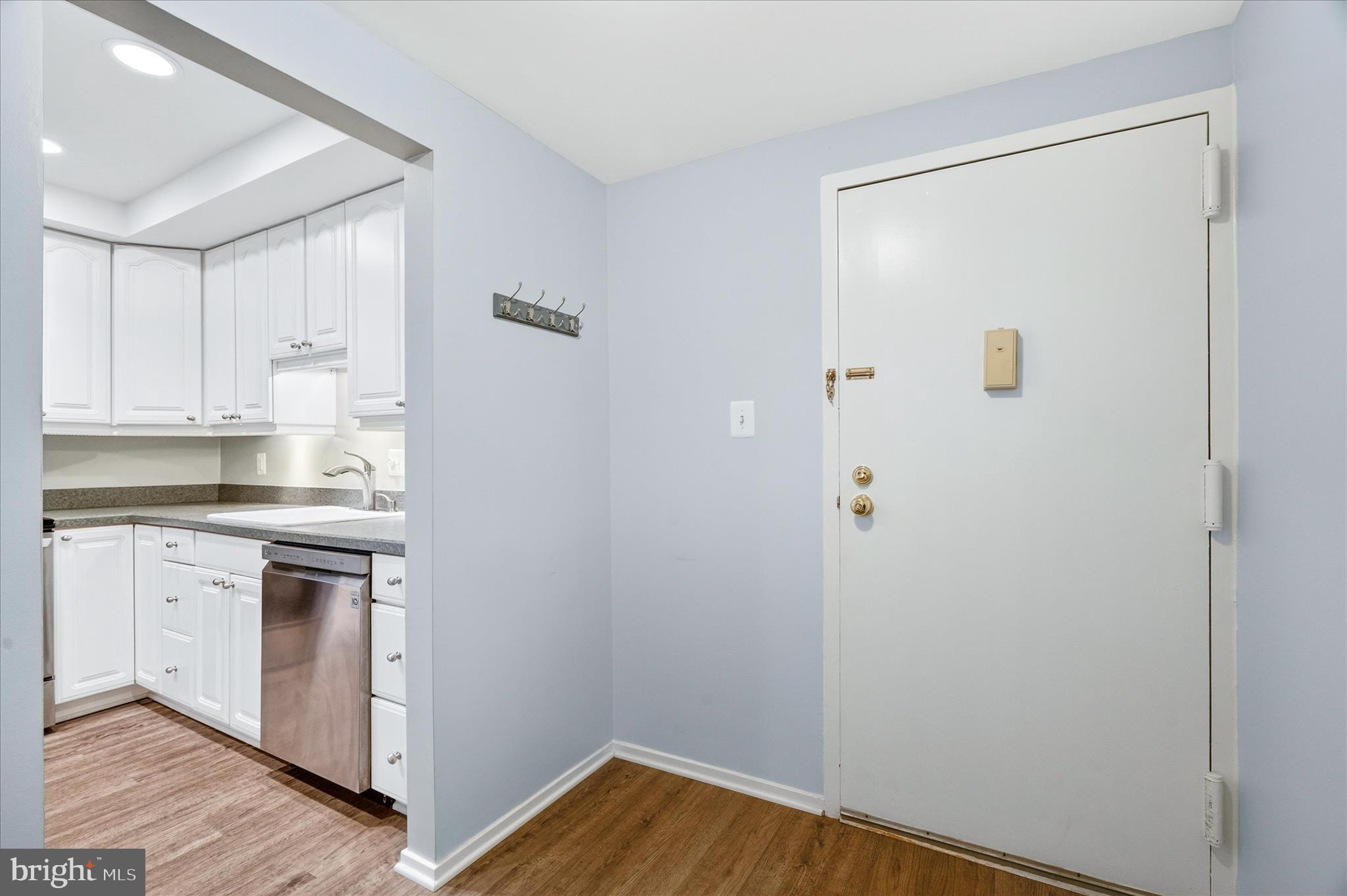10000 Stedwick Road, Unit 104 Montgomery Village, MD 20886 - Photo 4 of 31 a kitchen with a refrigerator and white cabinets