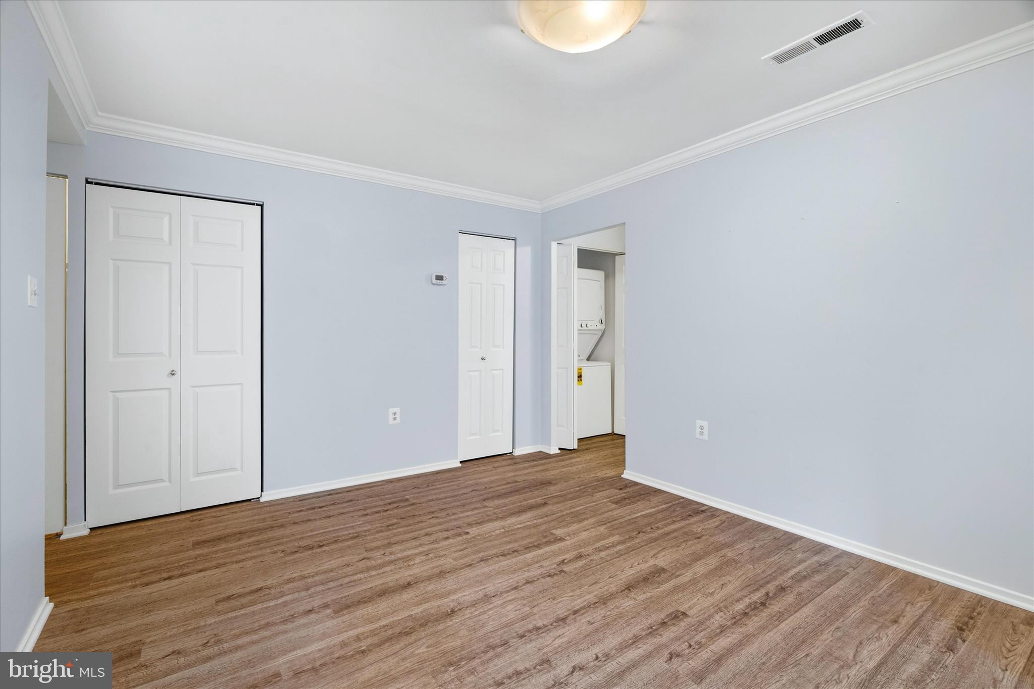 10000 Stedwick Road, Unit 104 Montgomery Village, MD 20886 - Photo 5 of 31 a view of an empty room with wooden floor and a window