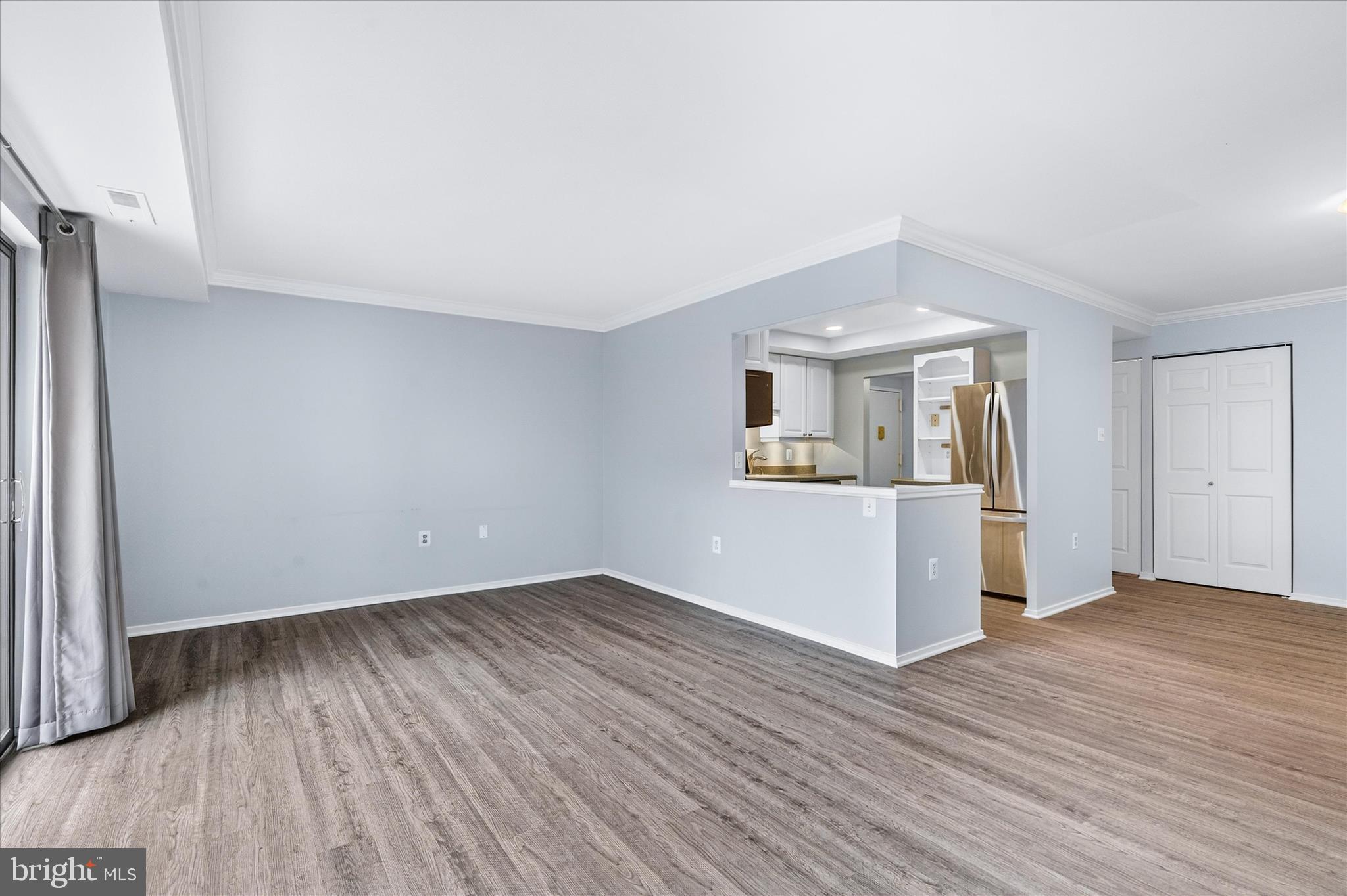 10000 Stedwick Road, Unit 104 Montgomery Village, MD 20886 - Photo 7 of 31 an empty room with wooden floor kitchen view and windows