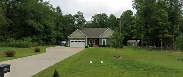 a front view of a house with a yard and trees
