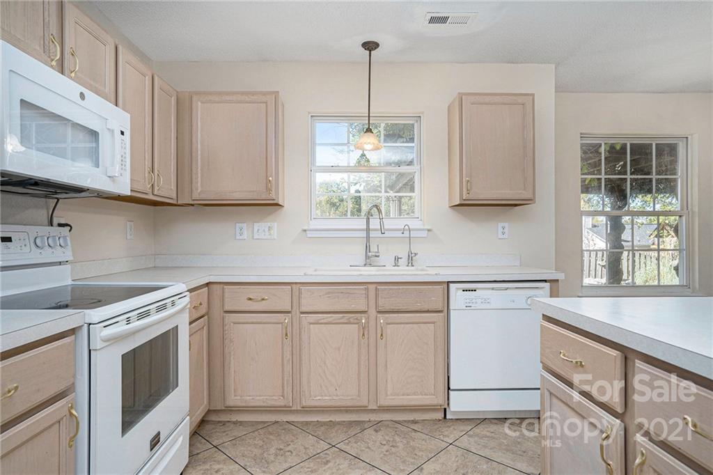 5532 Lemley Road Northwest Concord, NC 28027 - Photo 5 of 18 a kitchen with white cabinets appliances a sink and a window