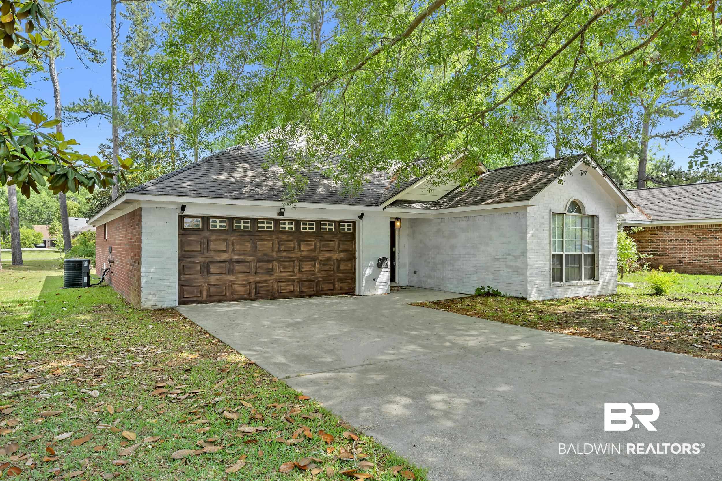 509 Loblolly Court Foley, AL 36535 - Photo 24 of 26 Single-story residence featuring a two-car garage with a wood-finish door, brick siding, and white painted exterior