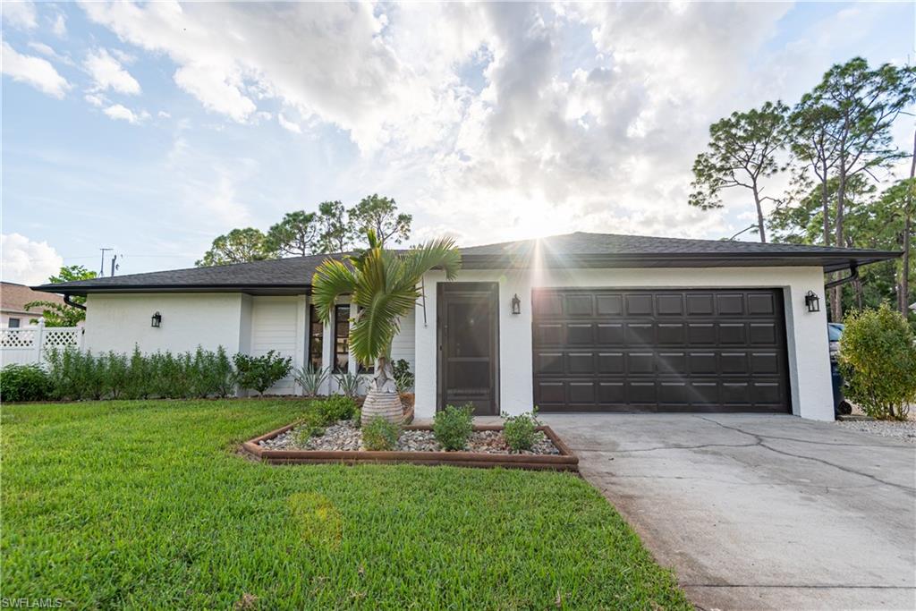18386 Tulip Road Fort Myers, FL 33967 - Photo 4 of 25 a front view of a house with a yard and garage