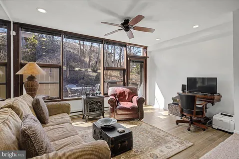 a living room with furniture a flat screen tv and a large window