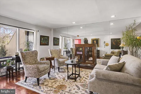 a living room with furniture and a dining table with wooden floor