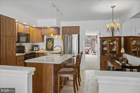 a kitchen with stainless steel appliances granite countertop a sink refrigerator and cabinets