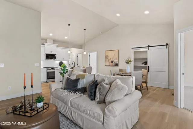 a living room with furniture kitchen and a chandelier