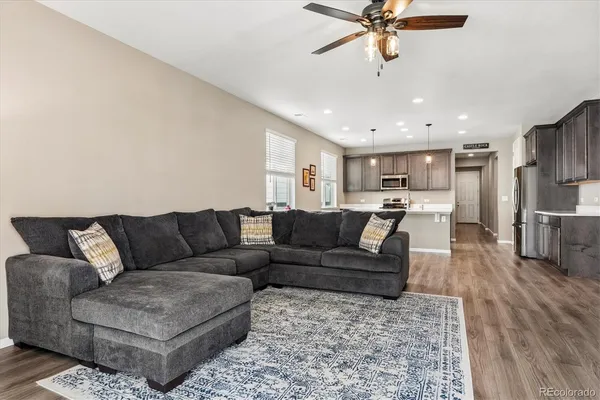 a living room with furniture kitchen view and a chandelier