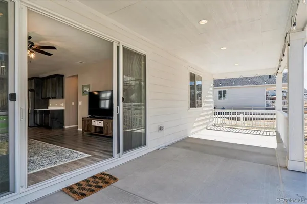 a view of a hallway with wooden floor and a living room