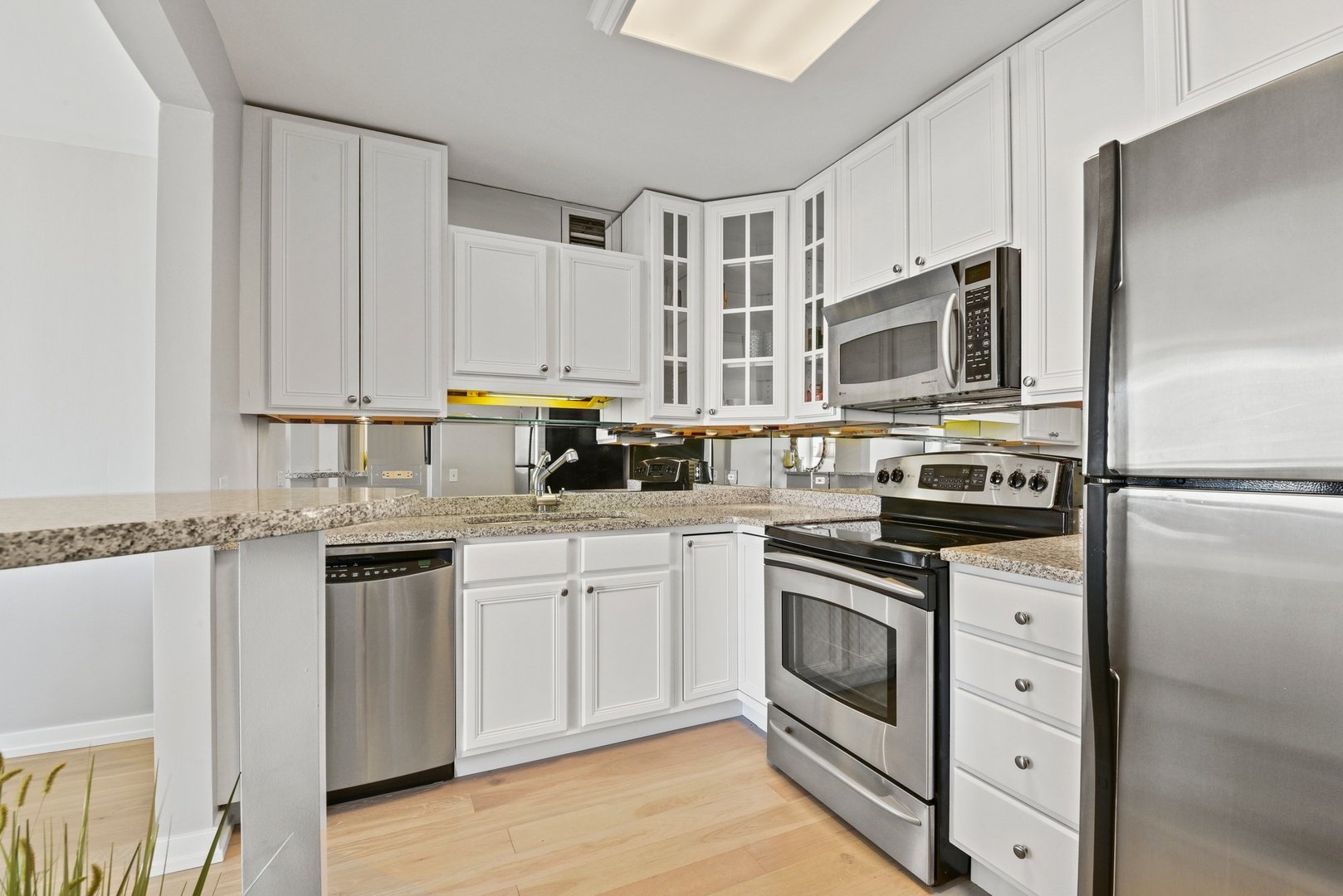 33 West Delaware Place, Unit 23D Chicago, IL 60610 - Photo 6 of 20 a kitchen with stainless steel appliances granite countertop a stove a sink and a refrigerator