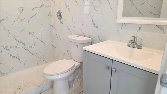 a white toilet sitting next to a bathroom sink
