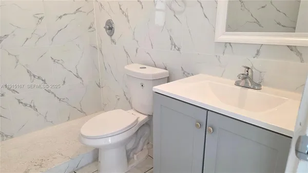 a white toilet sitting next to a bathroom sink