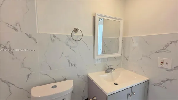 a bathroom with a sink vanity and toilet