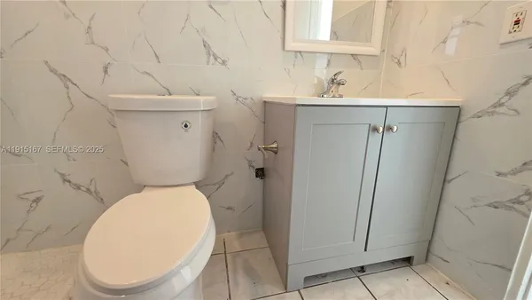 a white toilet sitting next to a bathroom sink