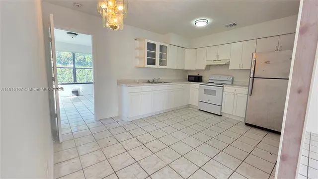 a kitchen with white cabinets and white appliances