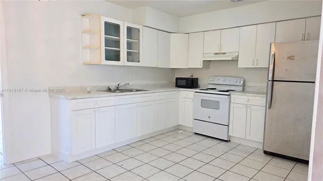 a kitchen with white cabinets and white appliances