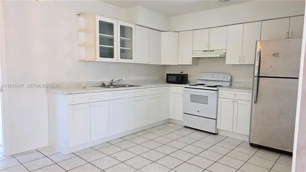 a kitchen with white cabinets and white appliances