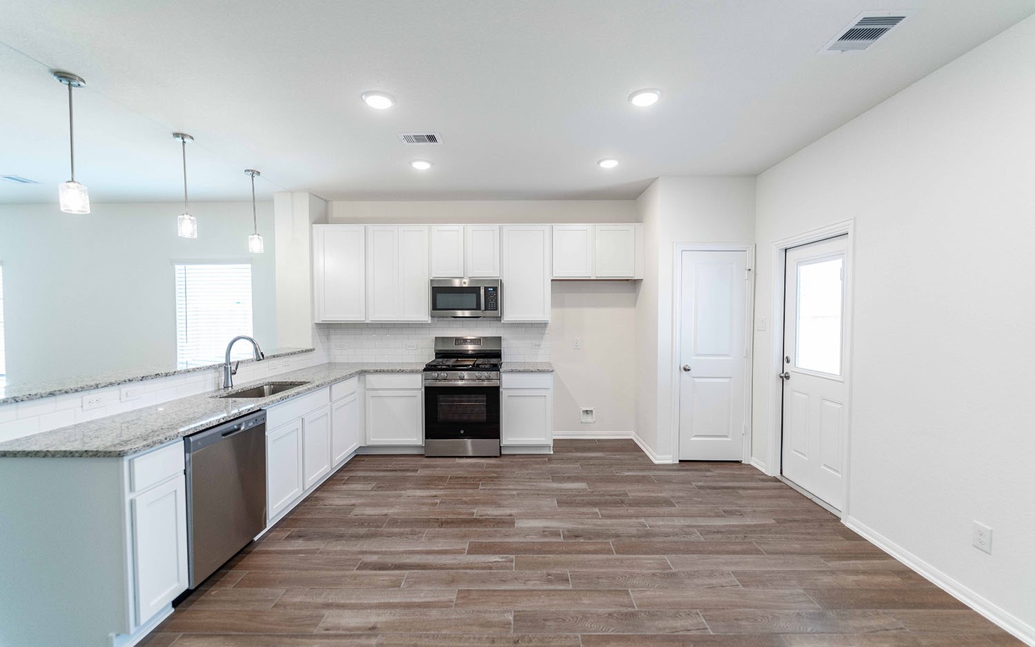10656 Altitude Way Conroe, TX 77303 - Photo 9 of 30 a large kitchen with stainless steel appliances kitchen island granite countertop a stove a refrigerator and a sink