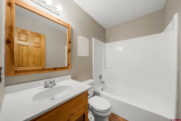 a bathroom with a sink toilet vanity and shower