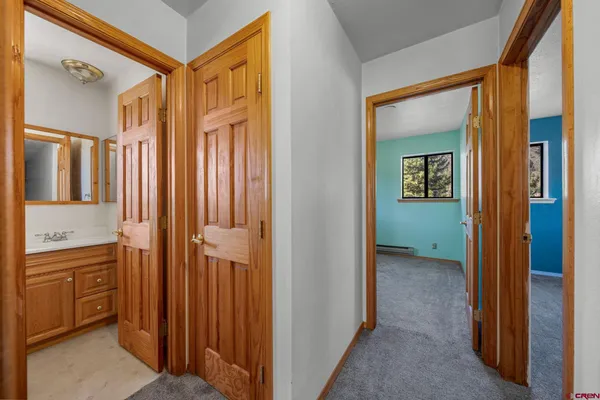 a view of a hallway with closet and mirror