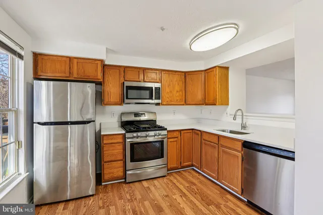 a kitchen with stainless steel appliances granite countertop a refrigerator sink and stove
