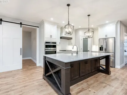 a kitchen with kitchen island a wooden floor and refrigerator