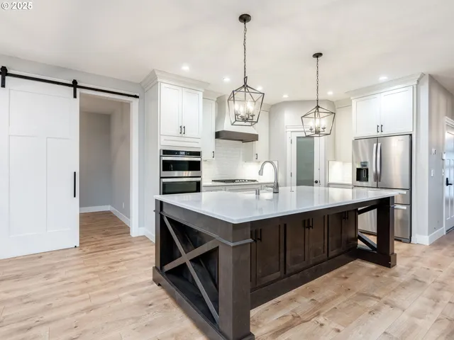 a kitchen with kitchen island a wooden floor and refrigerator