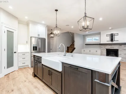 a large kitchen with stainless steel appliances a stove center island and cabinets