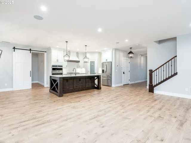 a view of kitchen and kitchen with a sink wooden floor and window