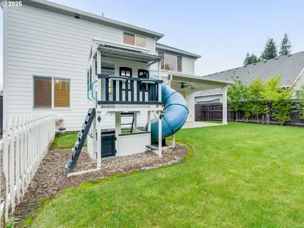 a view of an house with backyard and a tree