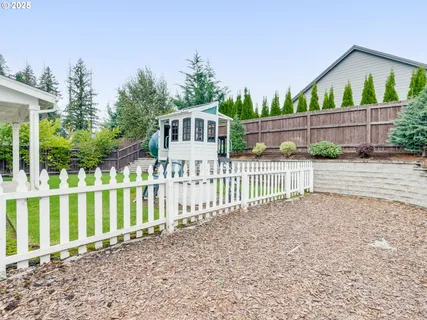 a view of a house with a small yard and wooden fence
